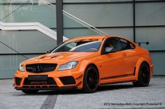 an orange car parked in front of a building