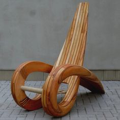 a wooden chair sitting on top of a brick floor next to a cement wall,