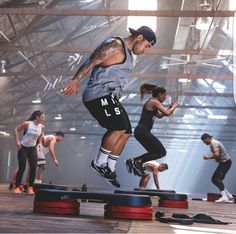 a group of men and women doing tricks on skateboards in an indoor gym area