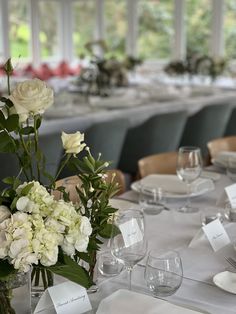 the table is set with white flowers and place cards