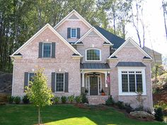 a brick house with white trim and black shutters