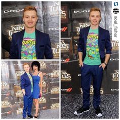 two people standing next to each other in front of a wall with teenage mutant t - shirts on