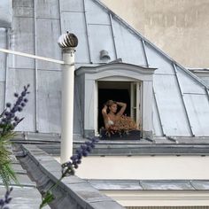 a woman standing in the window of an old building