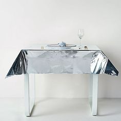 the table is covered with silver foil and has a wine glass on top of it