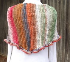 a white mannequin wearing a multicolored knitted shawl