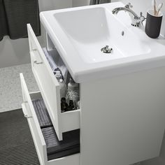 a white sink sitting under a bathroom mirror next to a black and white tiled floor