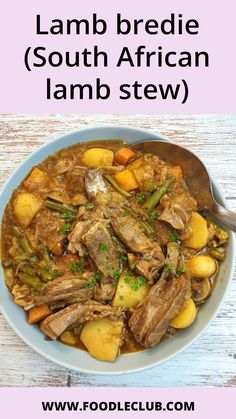 a bowl full of lamb stew with potatoes and broccoli in it on a wooden table