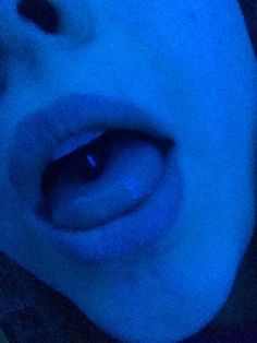 a close up of a person's mouth with blue light coming from behind it