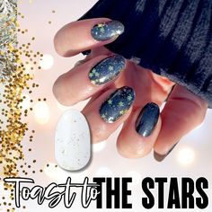 a woman's hand with black and gold nail polish on it, next to some glitter