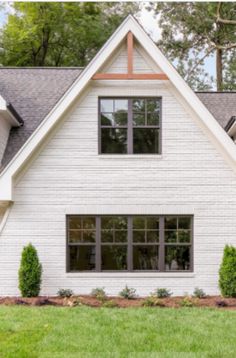 a white house with two large windows in the front yard