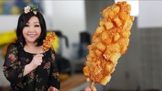 a woman holding up a piece of fried food