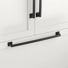 a white cabinet with two black handles on it