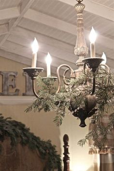 a chandelier hanging from the ceiling in a room with christmas decorations on it