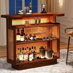 a bar with liquor bottles and glasses on the top shelf in front of a window