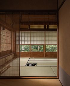 an empty room with tatami mats and windows