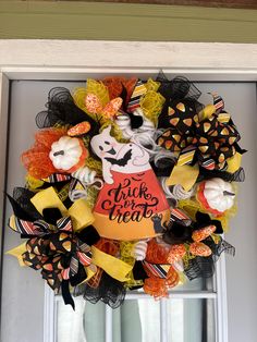 a trick or treat halloween wreath hanging on the front door