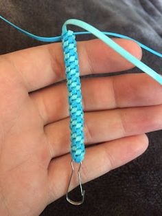 a person is holding a blue string in their hand