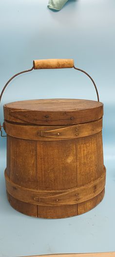 an old wooden box with a handle on the top is shown in front of a blue background