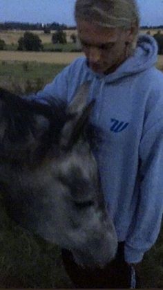 a woman is petting the head of a horse