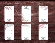 six cards with pink flowers on them sitting next to a wooden wall and wood planks