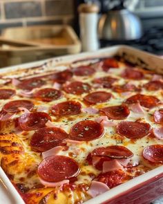 a pepperoni and cheese pizza in a pan on the stove top, ready to be eaten