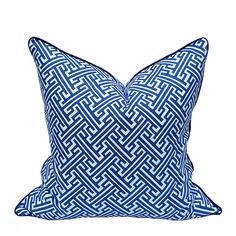 a blue and white pillow with an intricate design on the front, sitting against a white background