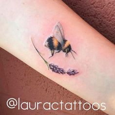 a bum tattoo on the arm with lavenders around it and a bee sitting on top