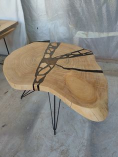 a wooden table with hairpin legs and a tree design on the top that is shaped like a train track