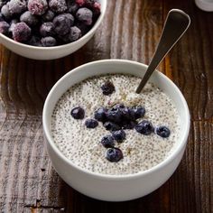 a bowl filled with oatmeal and blueberries on top of a wooden table