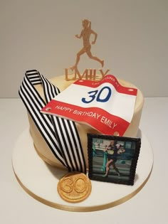 a birthday cake with a photo and ribbon on it, next to a gold medal