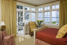 a bed sitting in a bedroom next to a window covered in yellow drapes and curtains