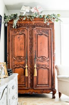 an ornate armoire with christmas decorations on top