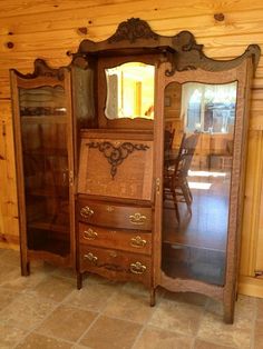 an antique dresser and mirror in the corner of a room