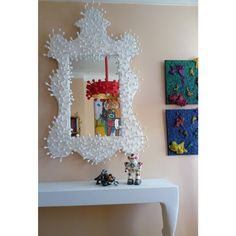 there is a white table with toys on it and a mirror hanging above the table