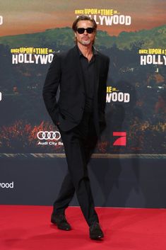 the actor is posing on the red carpet at the hollywood film festival in his black suit and sunglasses