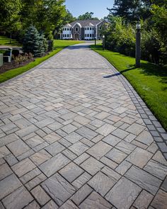 a brick walkway in front of a large house