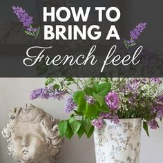 a vase filled with purple flowers sitting on top of a table next to a statue