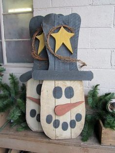 a wooden snowman sitting on top of a shelf