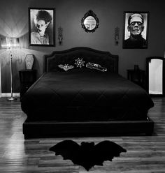 a black and white photo of a bed in a room with pictures on the wall