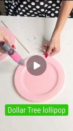 a person cutting into a pink paper plate