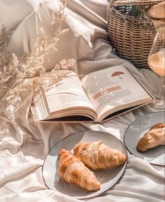 two croissants and an open book on a bed