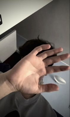 a person holding their hand out in front of the camera with both hands extended up