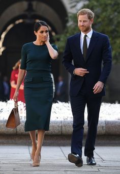 prince harry and his wife are walking down the street