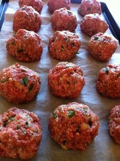 raw meatballs on a baking sheet ready to go into the oven or grilling