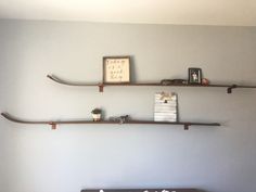 two wooden shelves on the wall above a bed