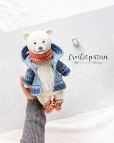 a hand holding a small stuffed animal in front of a white background with the words creditation written on it