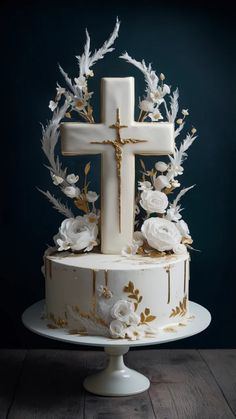 a white cake decorated with flowers and a cross on the top is sitting on a plate