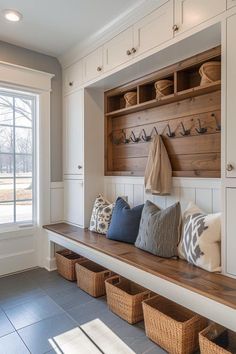 a wooden bench sitting under a window next to baskets on top of a countertop