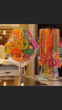 two glass vases filled with colorful beads