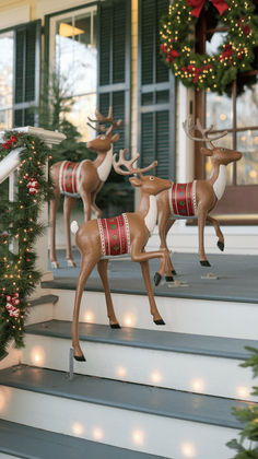 two reindeer figurines on the steps decorated for christmas